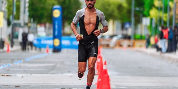 Focused male athlete running a marathon in an urban setting, showcasing endurance and determination.